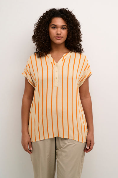 Model med stribet plus size t-shirt. T-shirten er sandfarvet med lodrette orange striber. T-shirten har v-hals og knapper. 